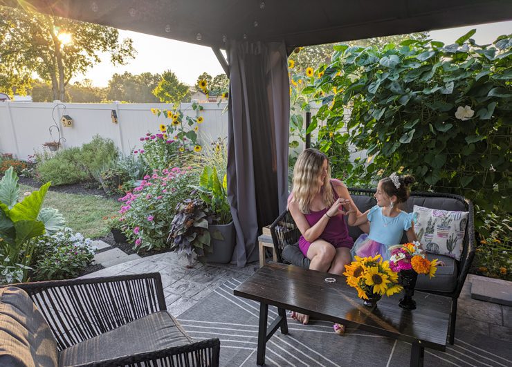 woman and child sitting on a beautiful patio with flowers and plants