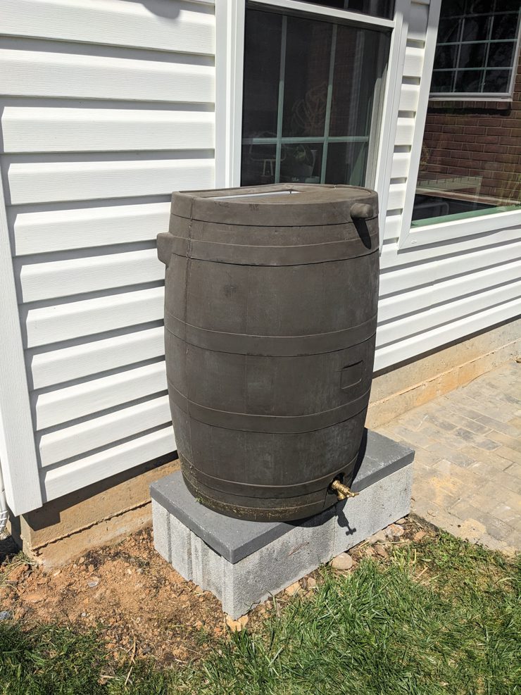 rain barrel up on cinderblocks and pavers