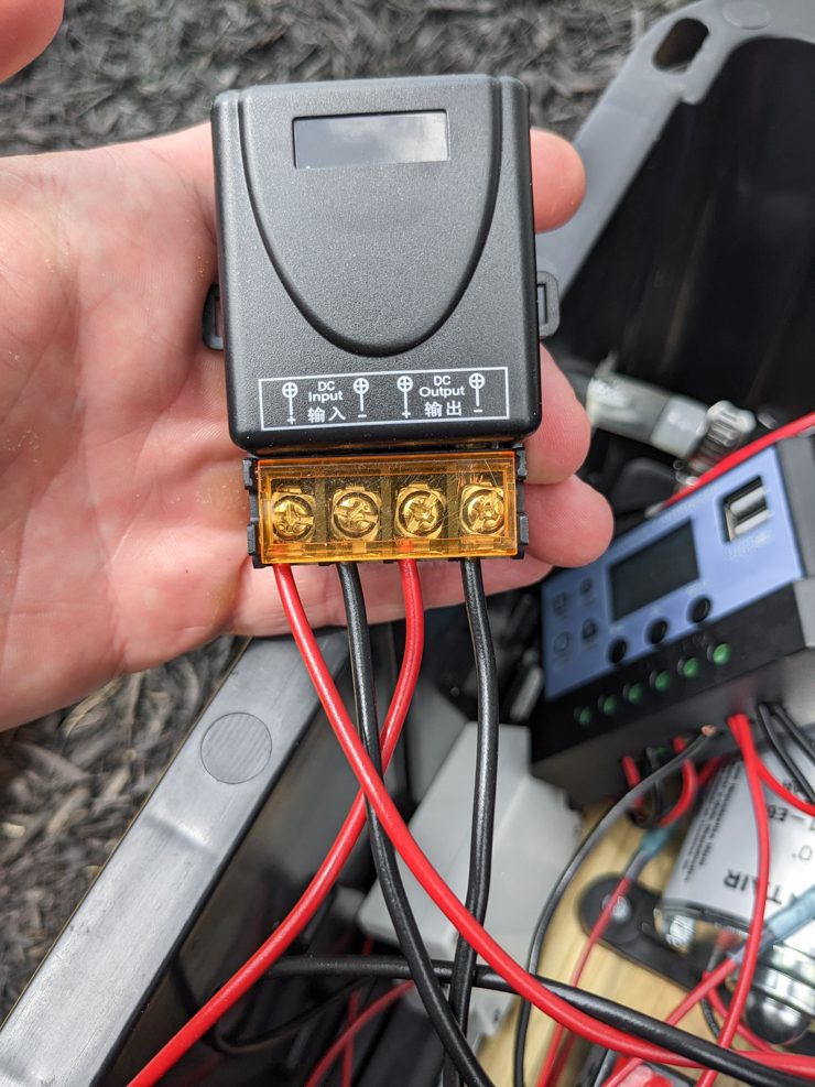 hand holding a box with wires coming out of it