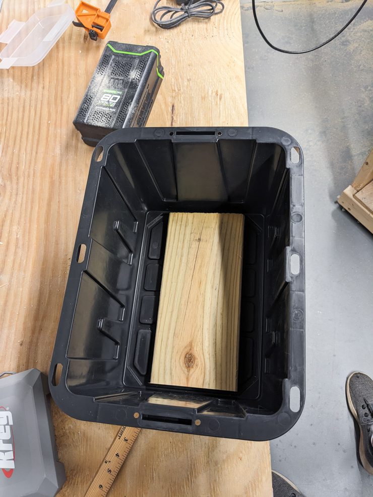 piece of wood in the bottom of a plastic box