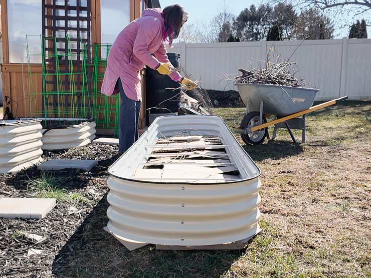 adding yard waste to a raised bed