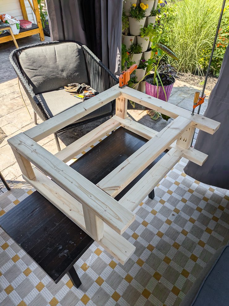 frame of a console table on its side with clamps